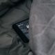 black Android smartphone on gray sheet