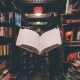 view of floating open book from stacked books in library