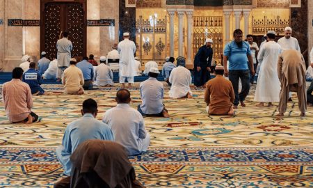 men kneeling and bowing inside building