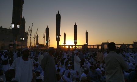 people standing near high rise building during sunset