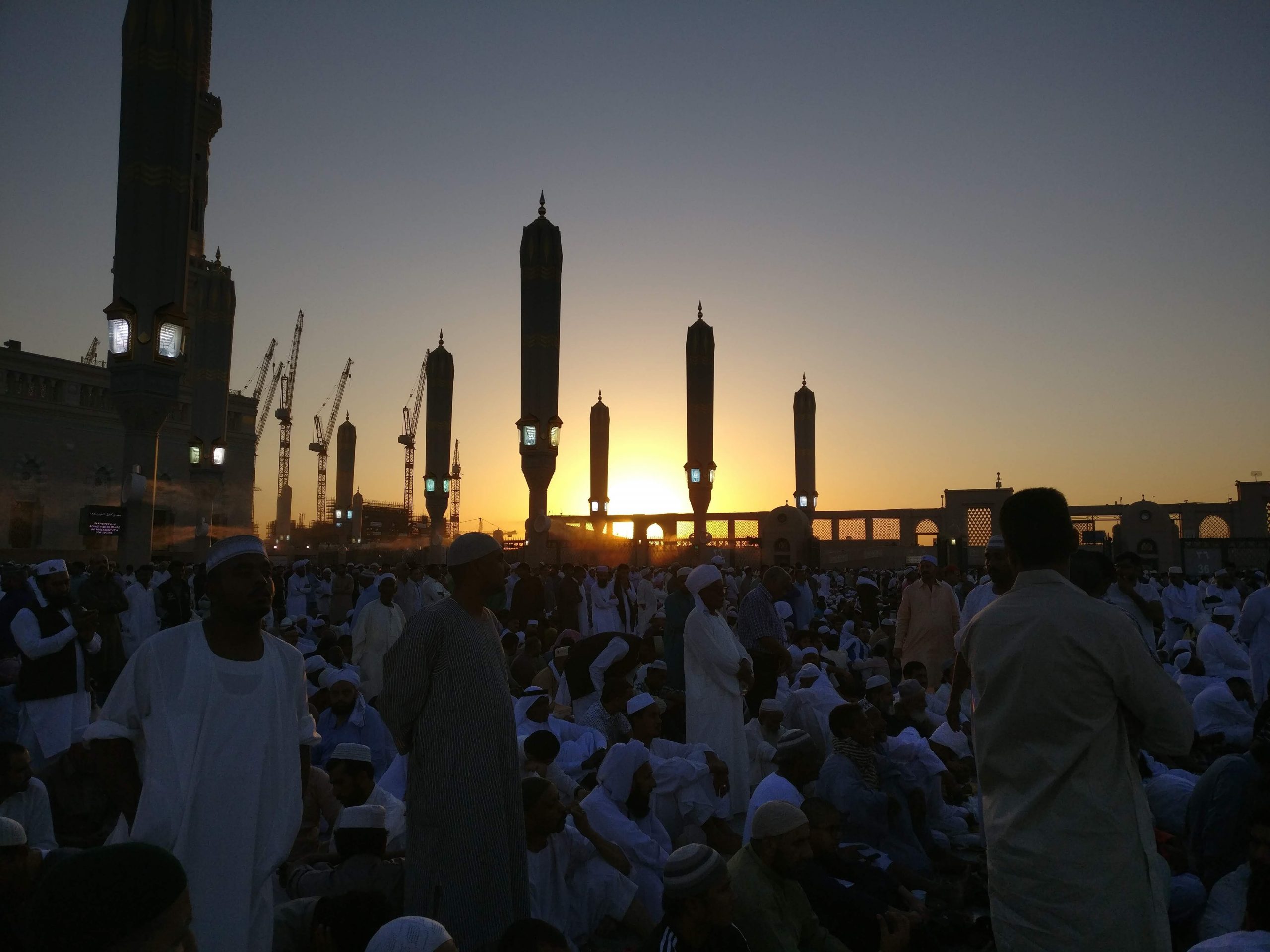 people standing near high rise building during sunset