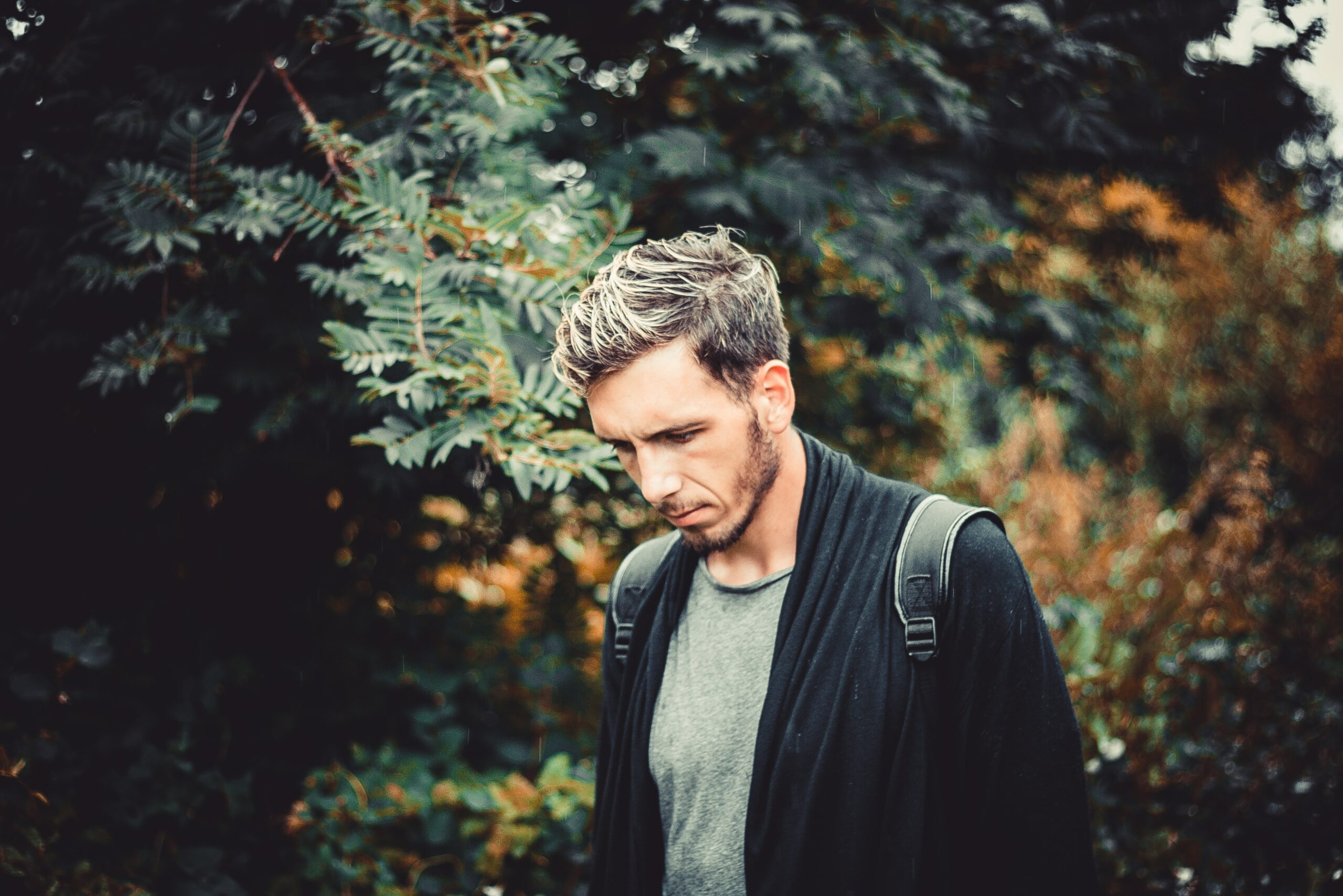 selective focus photography of man standing near tree