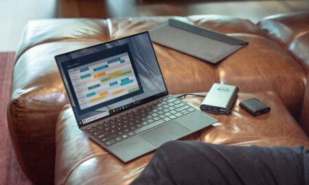 black and gray laptop computer on brown leather couch