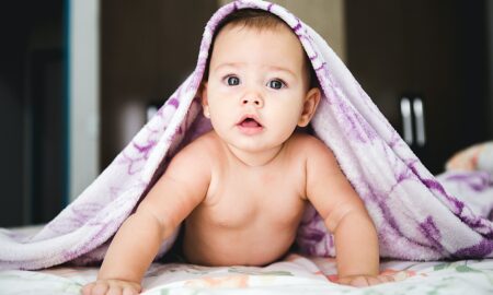 baby under purple blanket