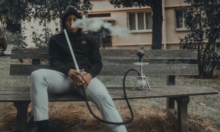 man in black zip up jacket smoking cigarette