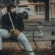 man in black zip up jacket smoking cigarette