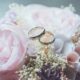 gold-colored bridal ring set on pink rose flower bouquet