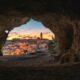 brown cave with over-view of city