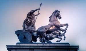 two men riding carriage statue