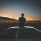 man sitting on gray sedan