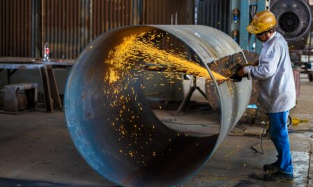 man wearing yellow hard hat holding angle grinder