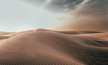 sand dunes at desert under grey cloudy sky