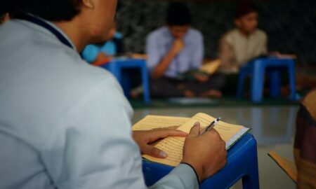 man in white dress shirt reading book