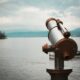 brown and silver telescope near body of water during daytime