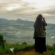 woman in black and white hijab standing on green grass field during daytime