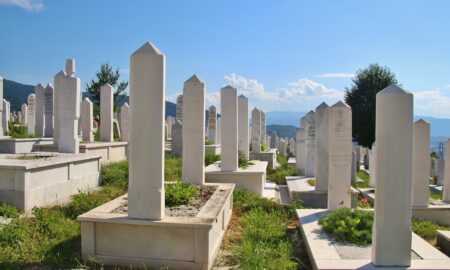 white concrete cross on green grass during daytime