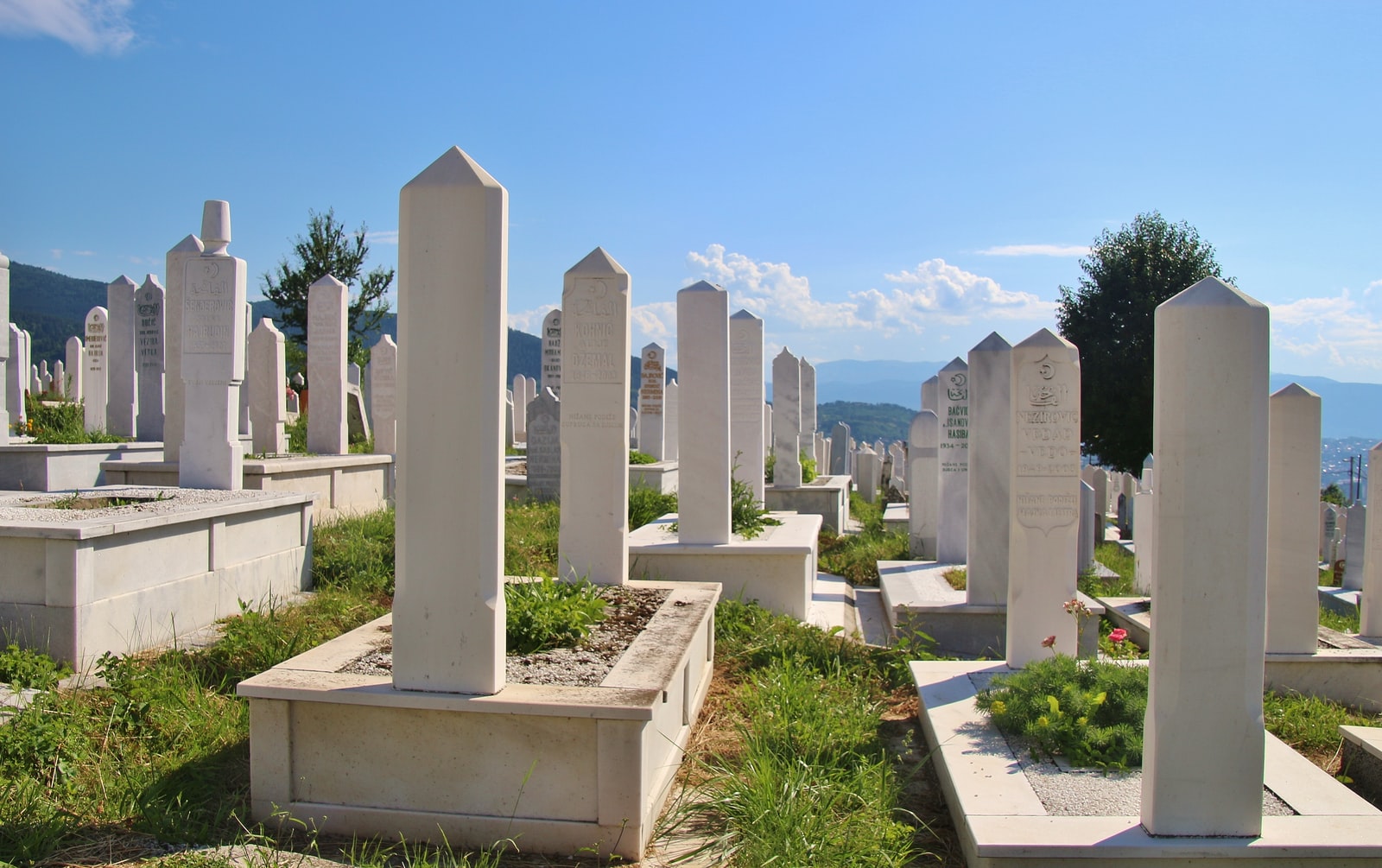 white concrete cross on green grass during daytime