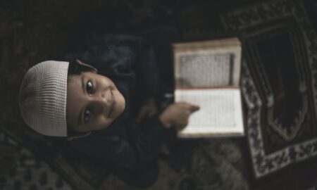 Boy in Head Covering Reading Quran