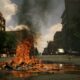 fire burning on the road with high rise buildings during daytime photography