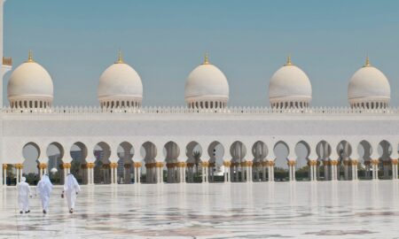 Three Men Walking in Front of a Dome Building