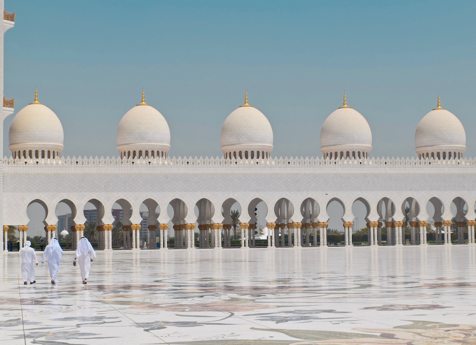 Three Men Walking in Front of a Dome Building