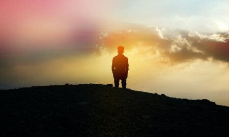 silhouette of person standing on hill