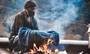 man heating clothing on fire