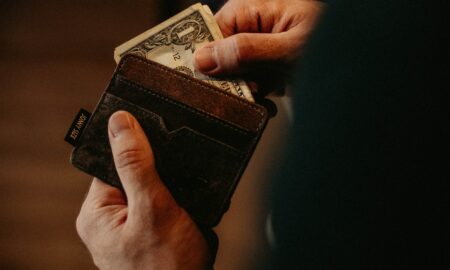 person getting 1 U.S. dollar banknote in wallet