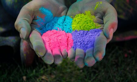 a person with their hands covered in colored powder