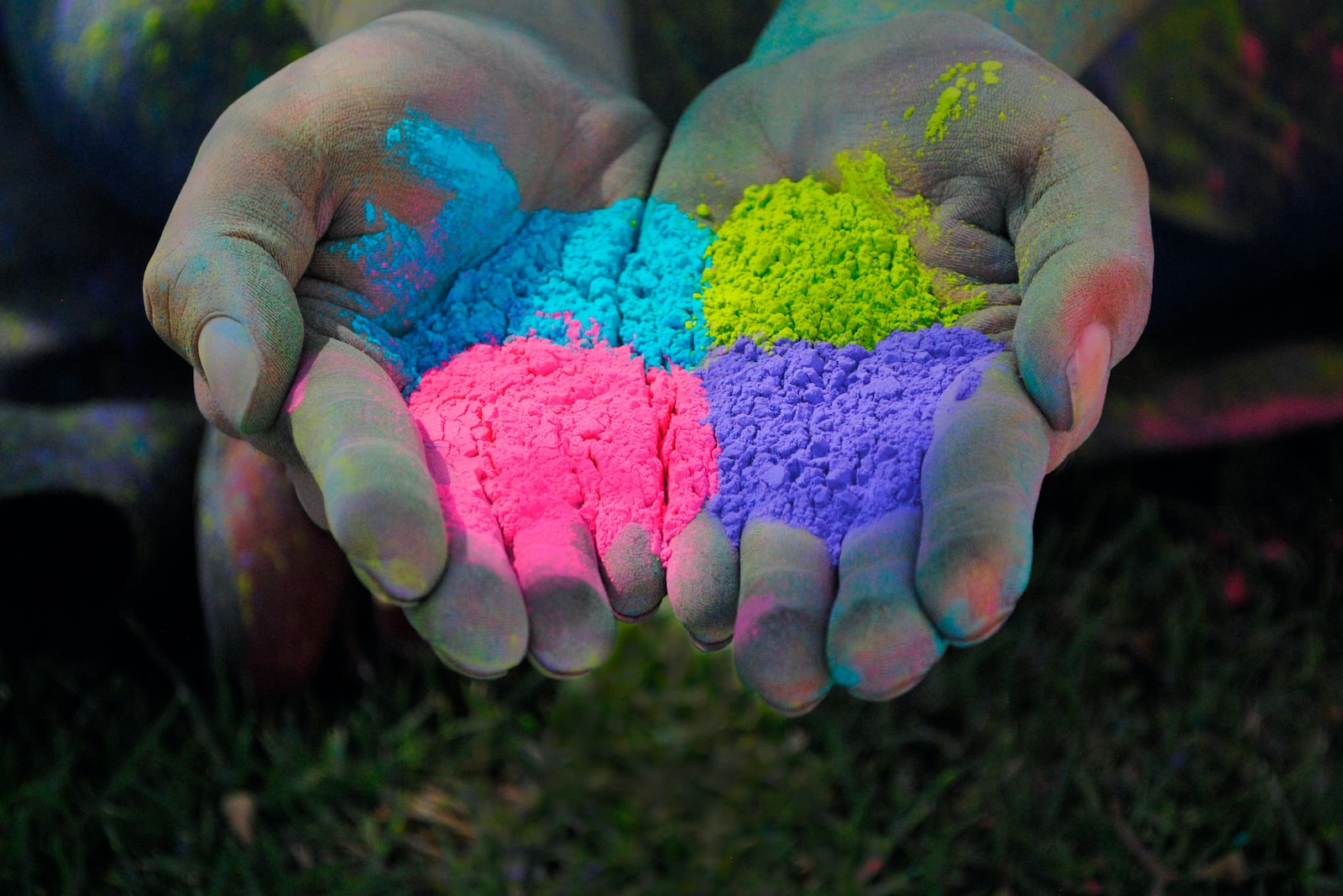 a person with their hands covered in colored powder