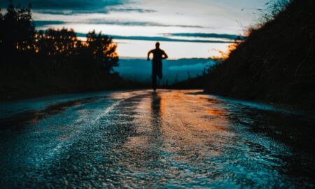 silhouette photo of a person running on road