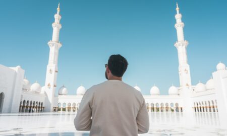 a man standing in front of a white building