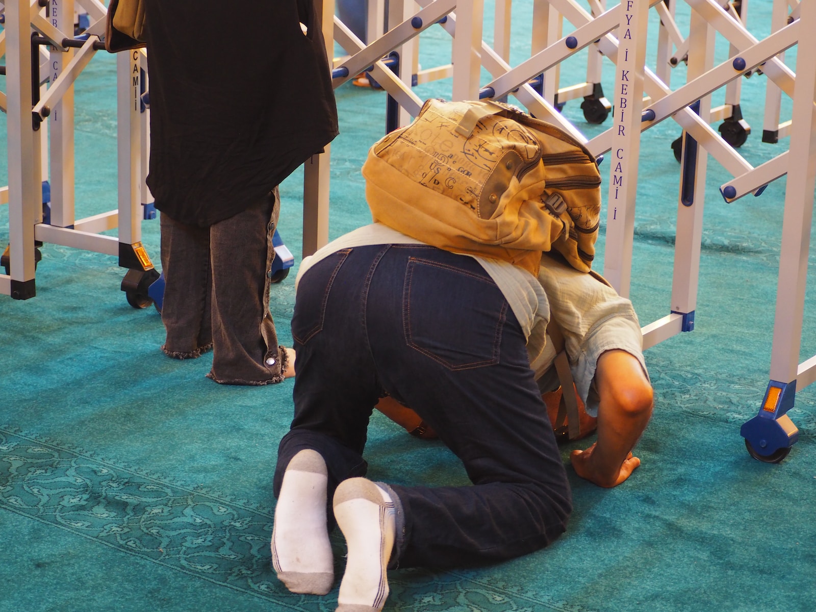 a man kneeling on the ground with a backpack on his head