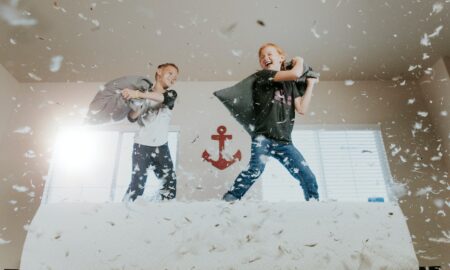 two toddler pillow fighting