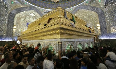 a crowd of people standing around a golden shrine