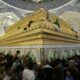 a crowd of people standing around a golden shrine