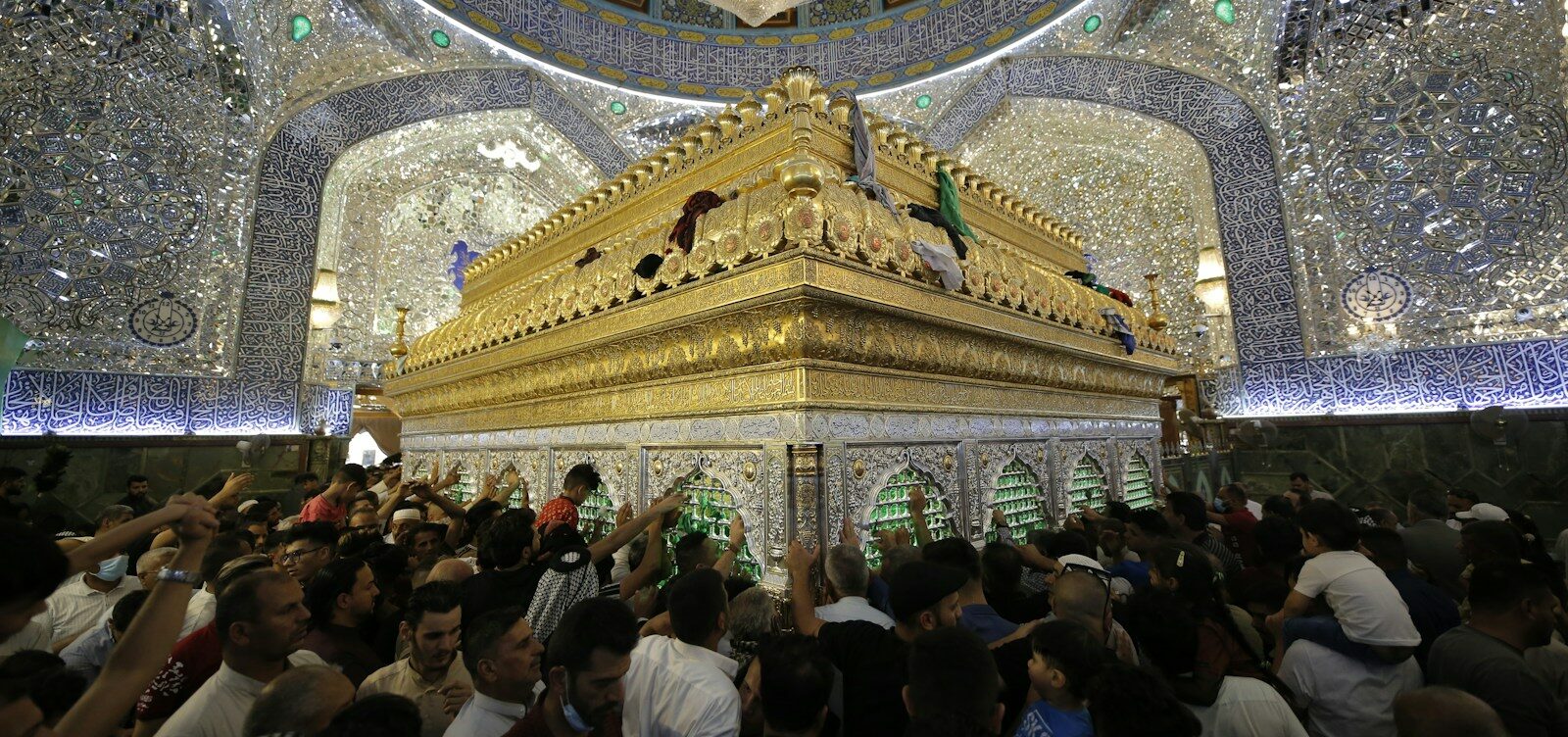 a crowd of people standing around a golden shrine