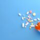 colorful pills spilling from orange bottle